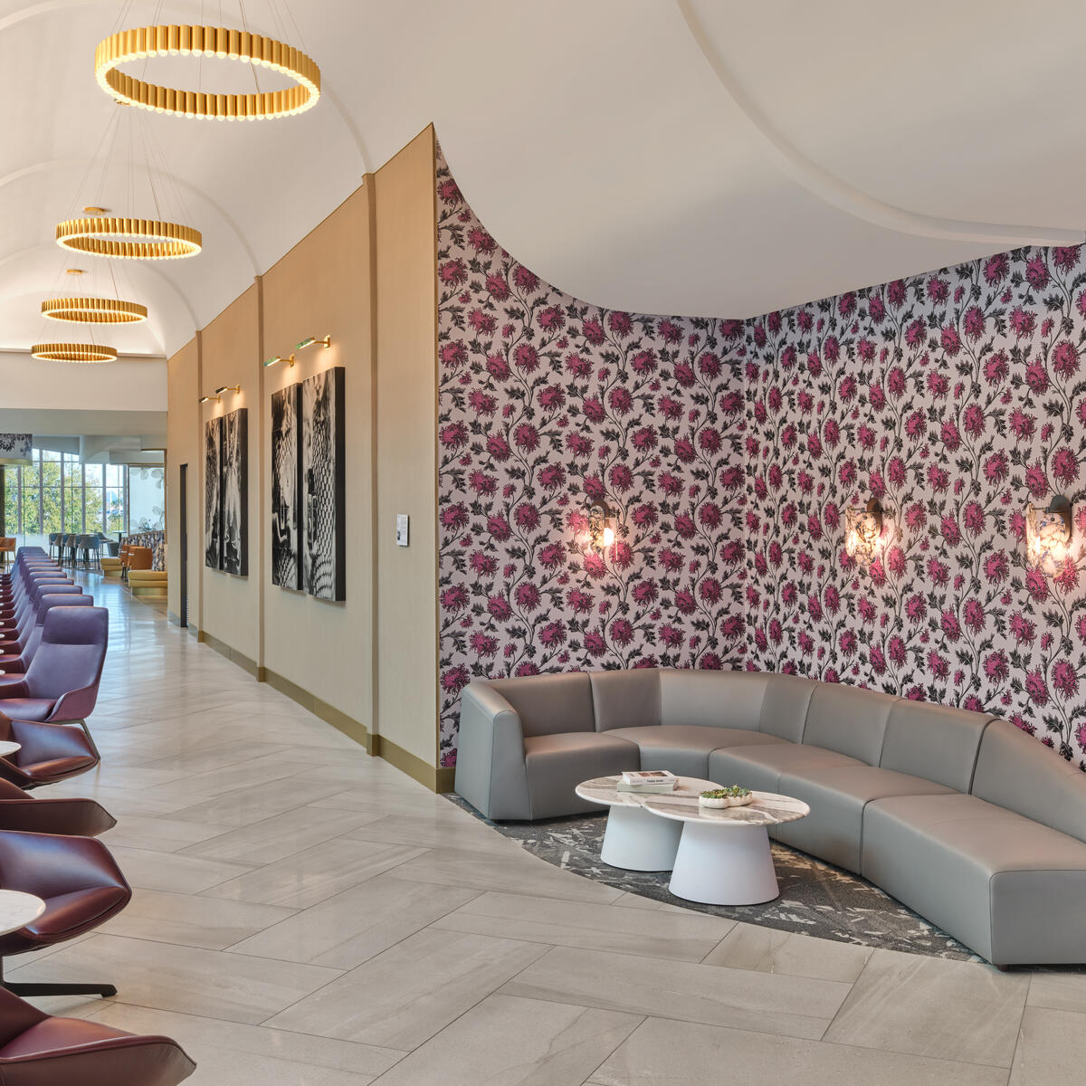 Interior of Delta's new CLT Sky Club, showing pink floral wallpapered wall and long windowed corridor.