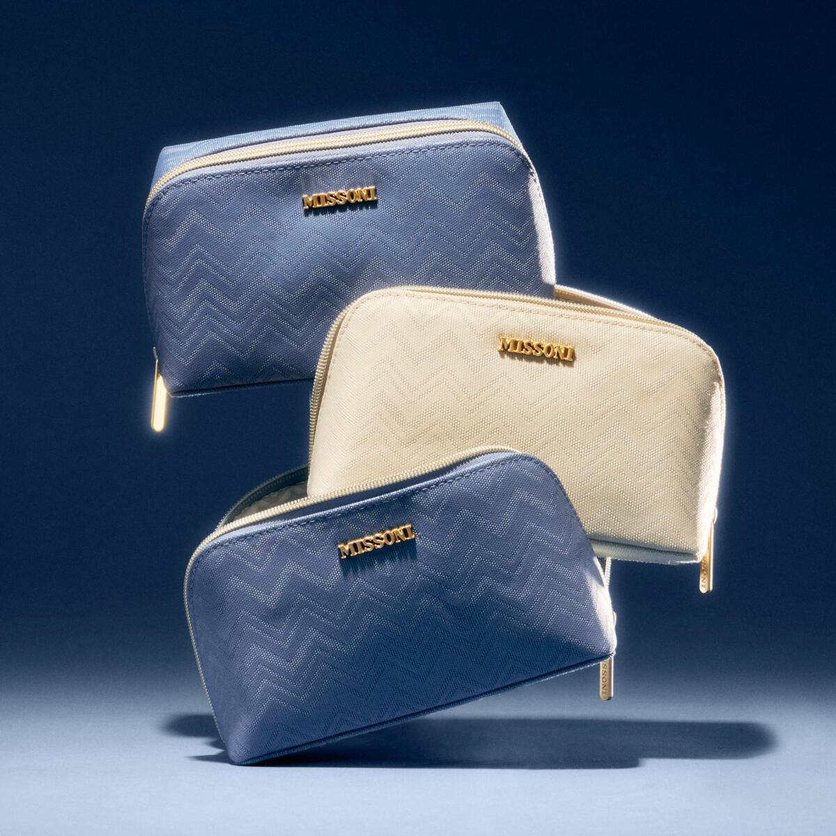 Three Delta x Missoni amenity kits are stacked on top of eachother.