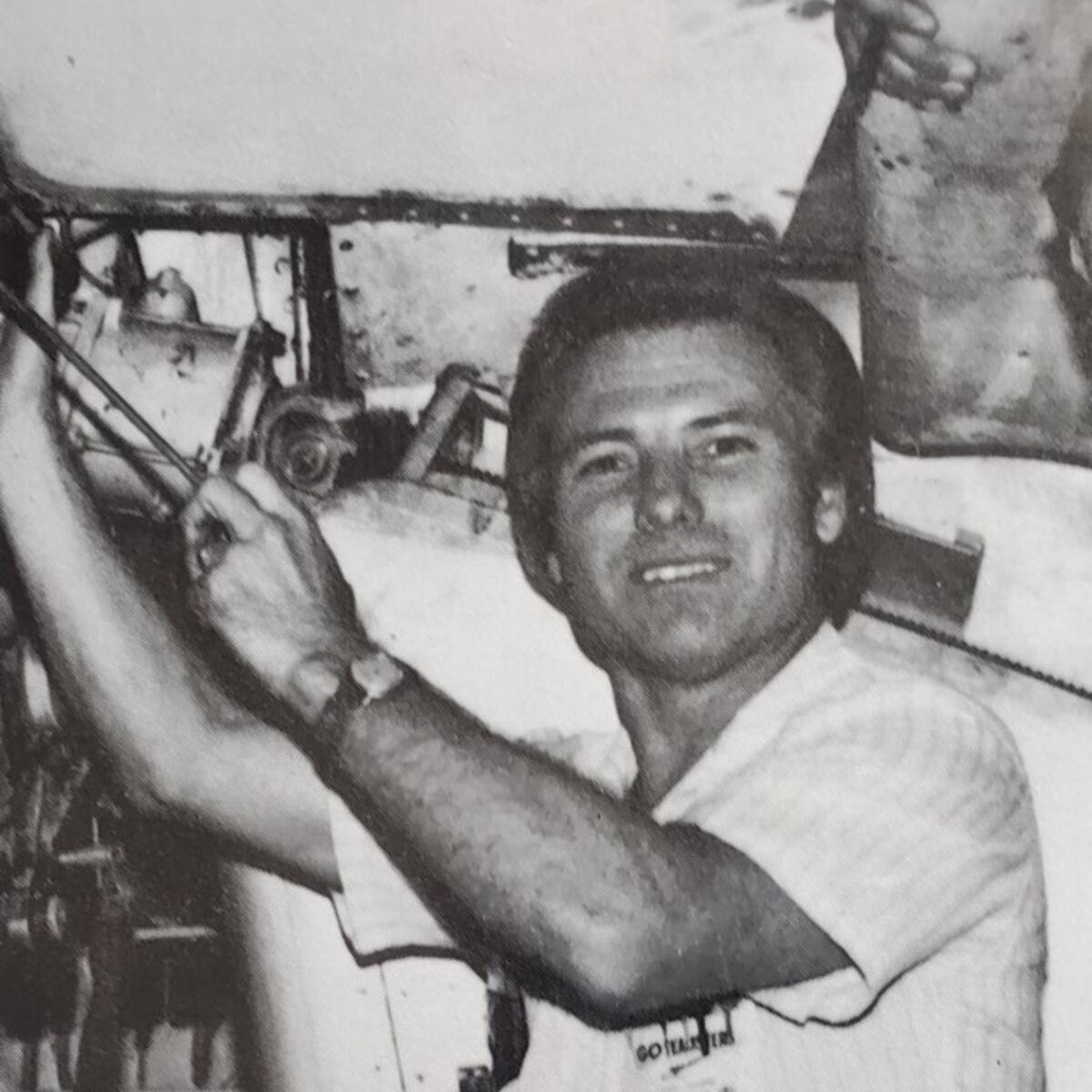 Black and white photo of Jimmy working on an airplane