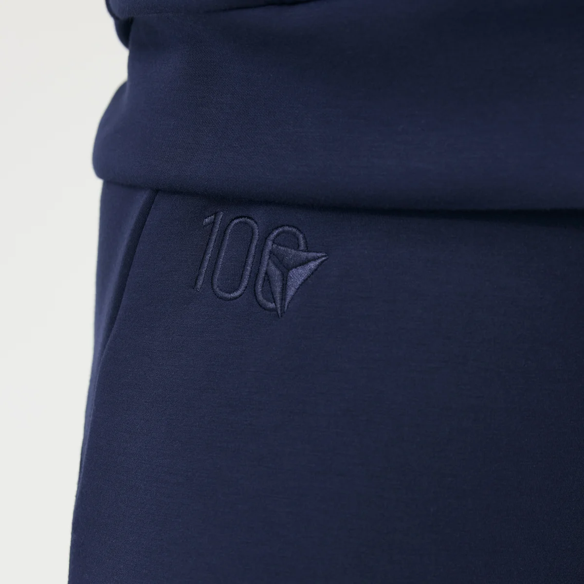 Close up of Delta Centennial logo embroidered on navy wide leg Spanx pants.