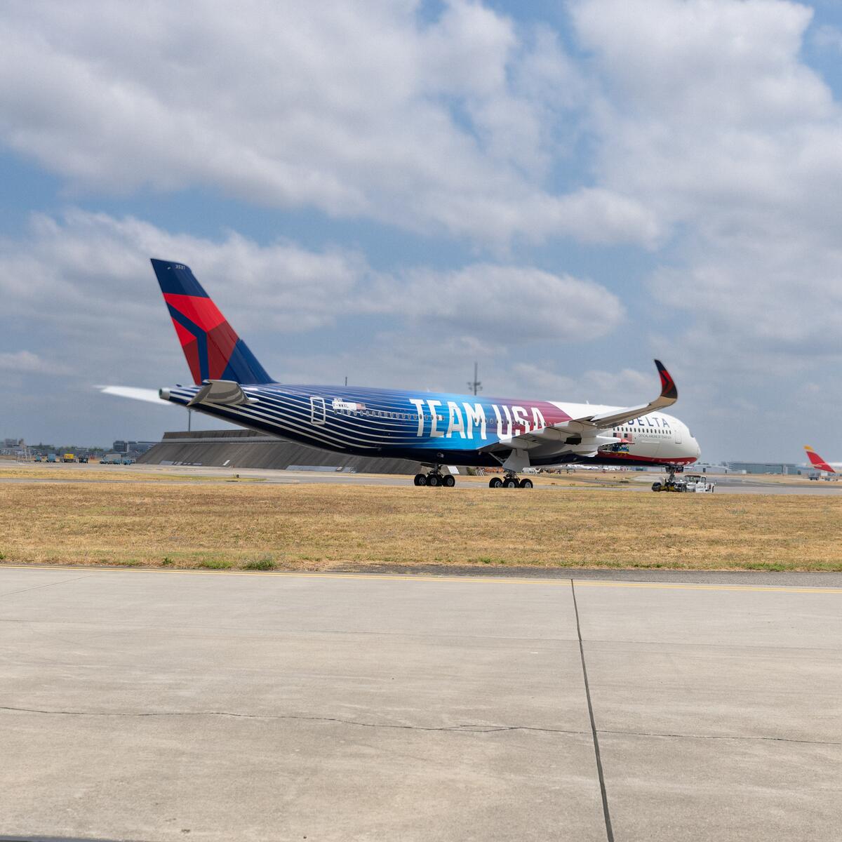 Delta airplane with Team USA livery taxing on runway.