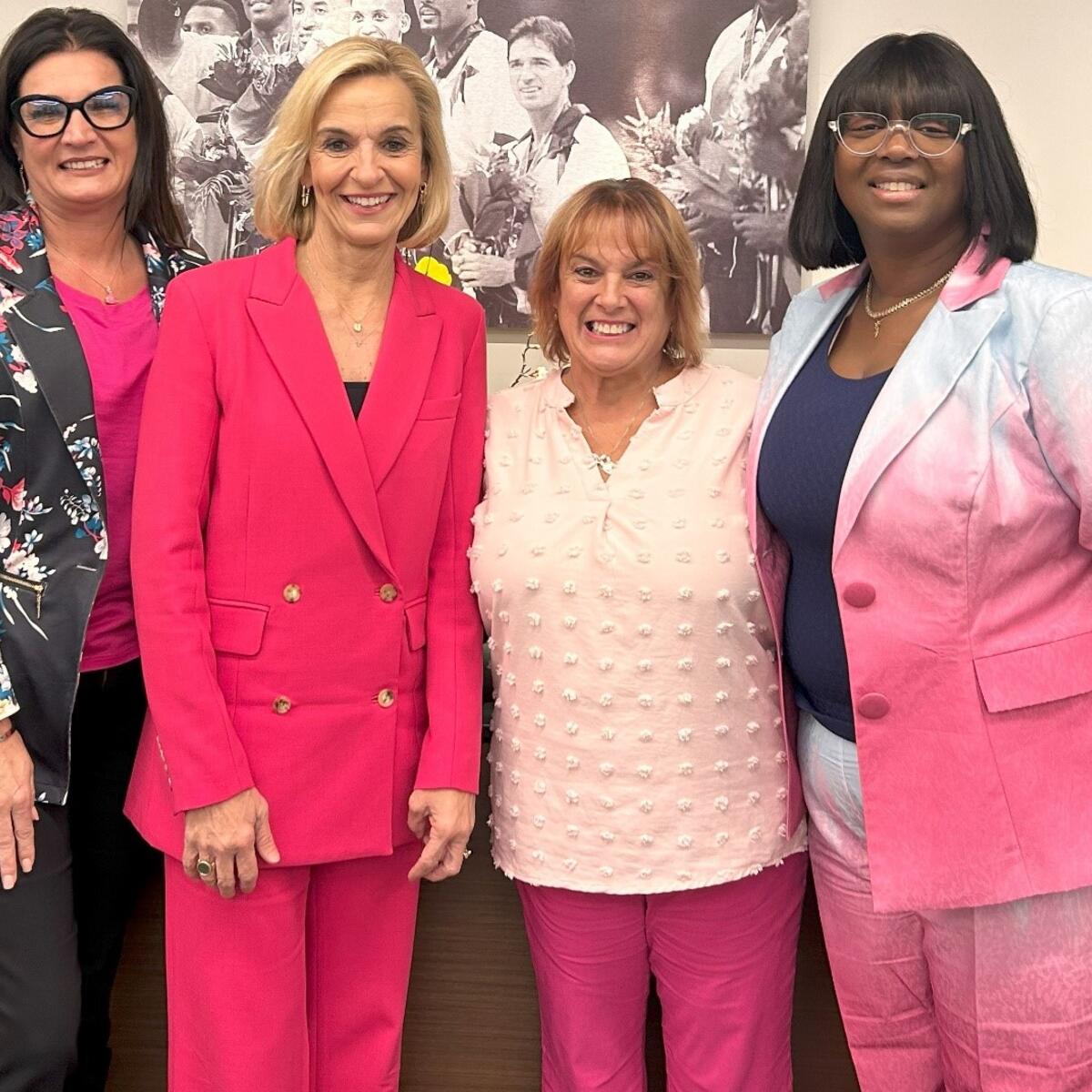 EVP and Chief People Officer Allison Ausband posing with three Delta employee breast cancer survivors.