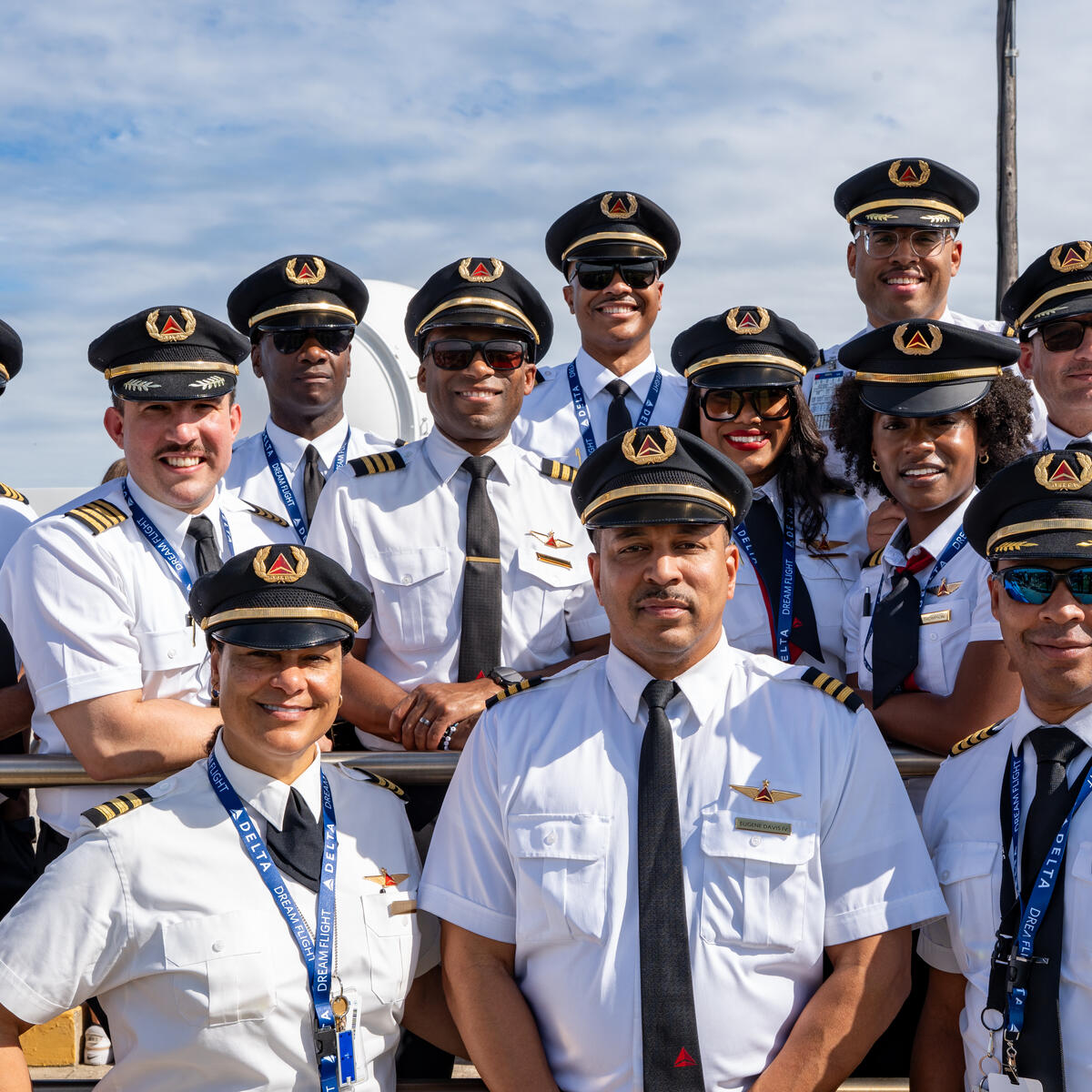 Group of Delta pilots in uniform posing outdoors.