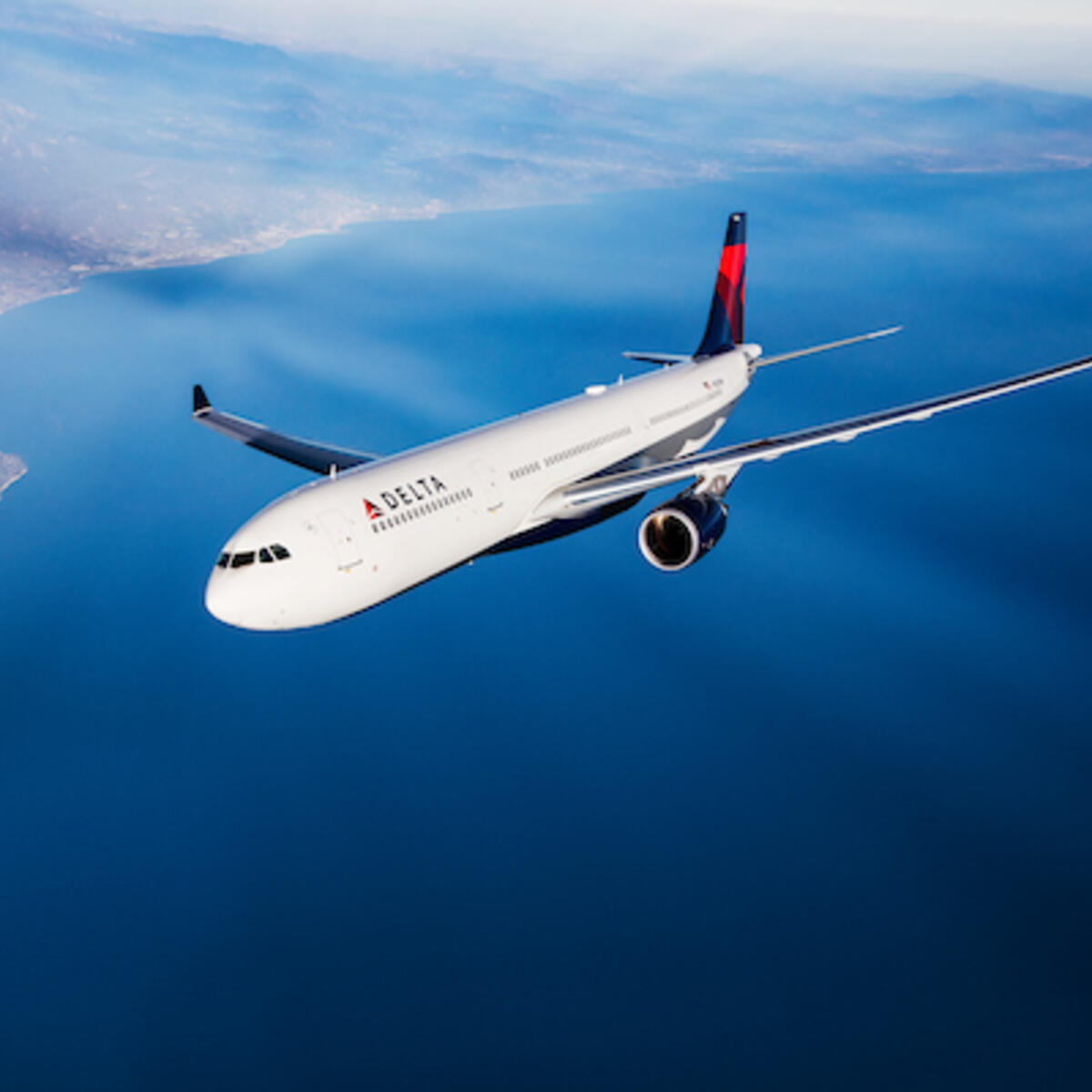 A Delta branded A330 flies in the sky. 