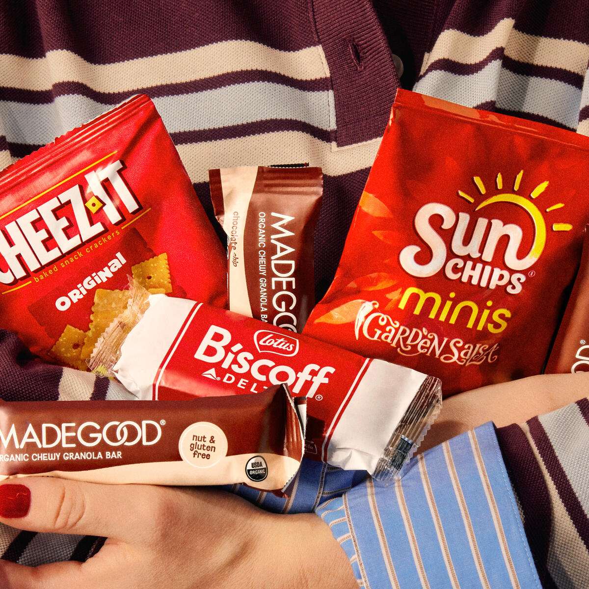Someone holds an armful of snack served on Delta flights