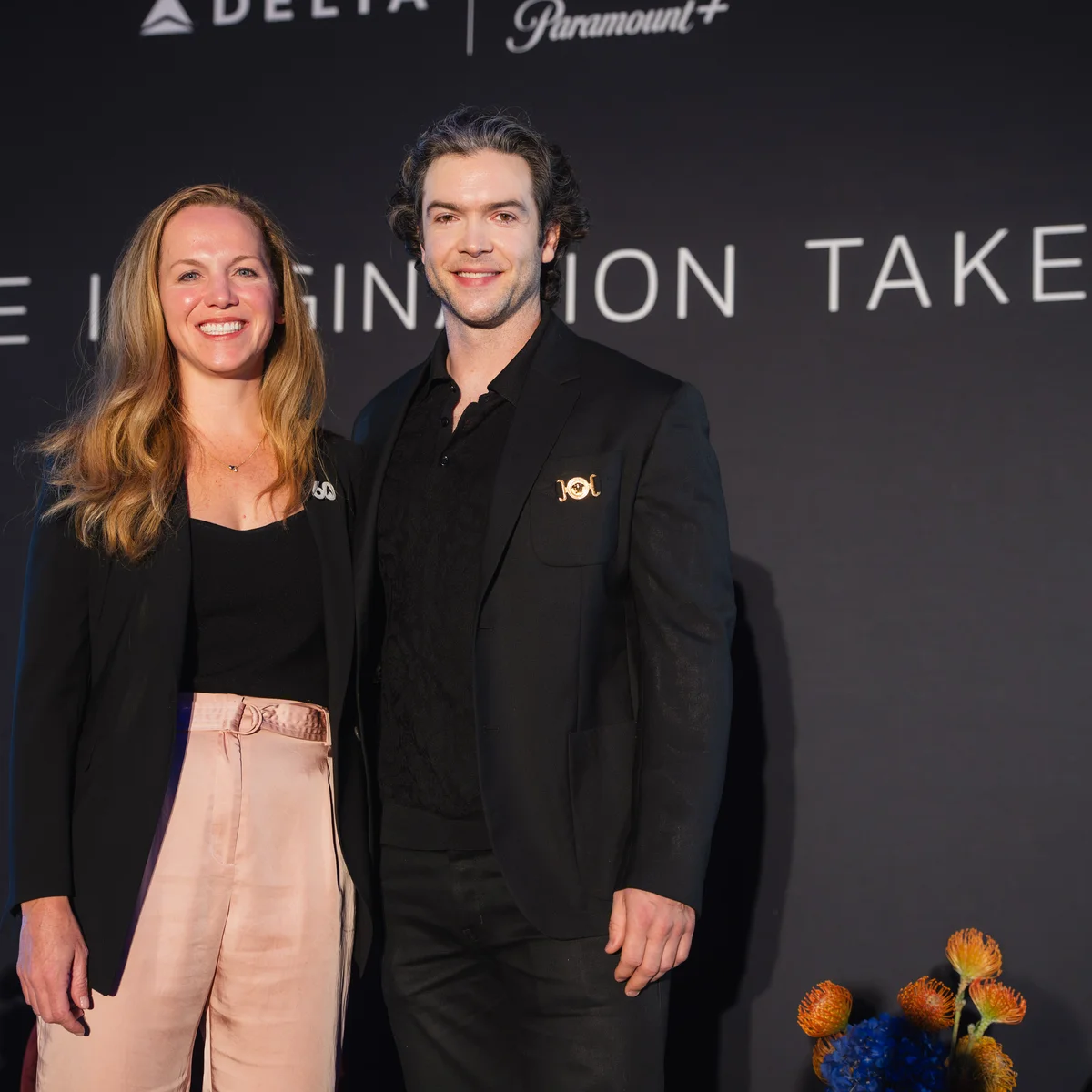 Delta and Paramount+ event attendees pose in front of a backdrop reading “Where Imagination Takes Flight.”