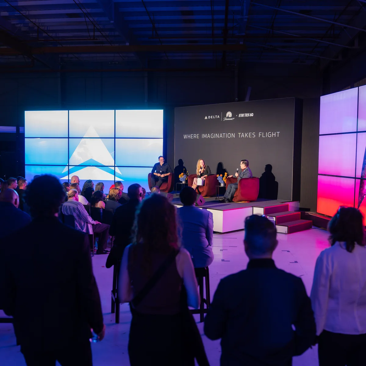 Audience members watch a panel discussion onstage at a Delta and Paramount+ Star Trek 60 event.