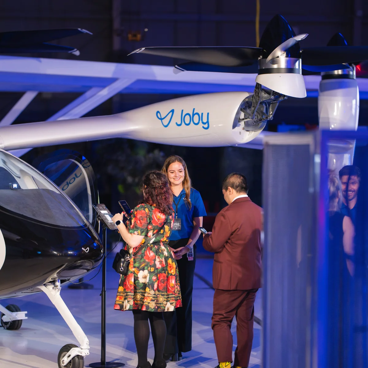 Guests view a Joby electric air taxi aircraft display during a Delta event.