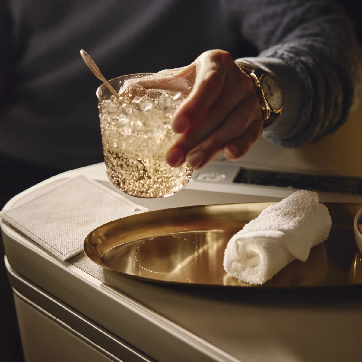 Beverage and mixed nuts served on a tray table in a Delta One suite.