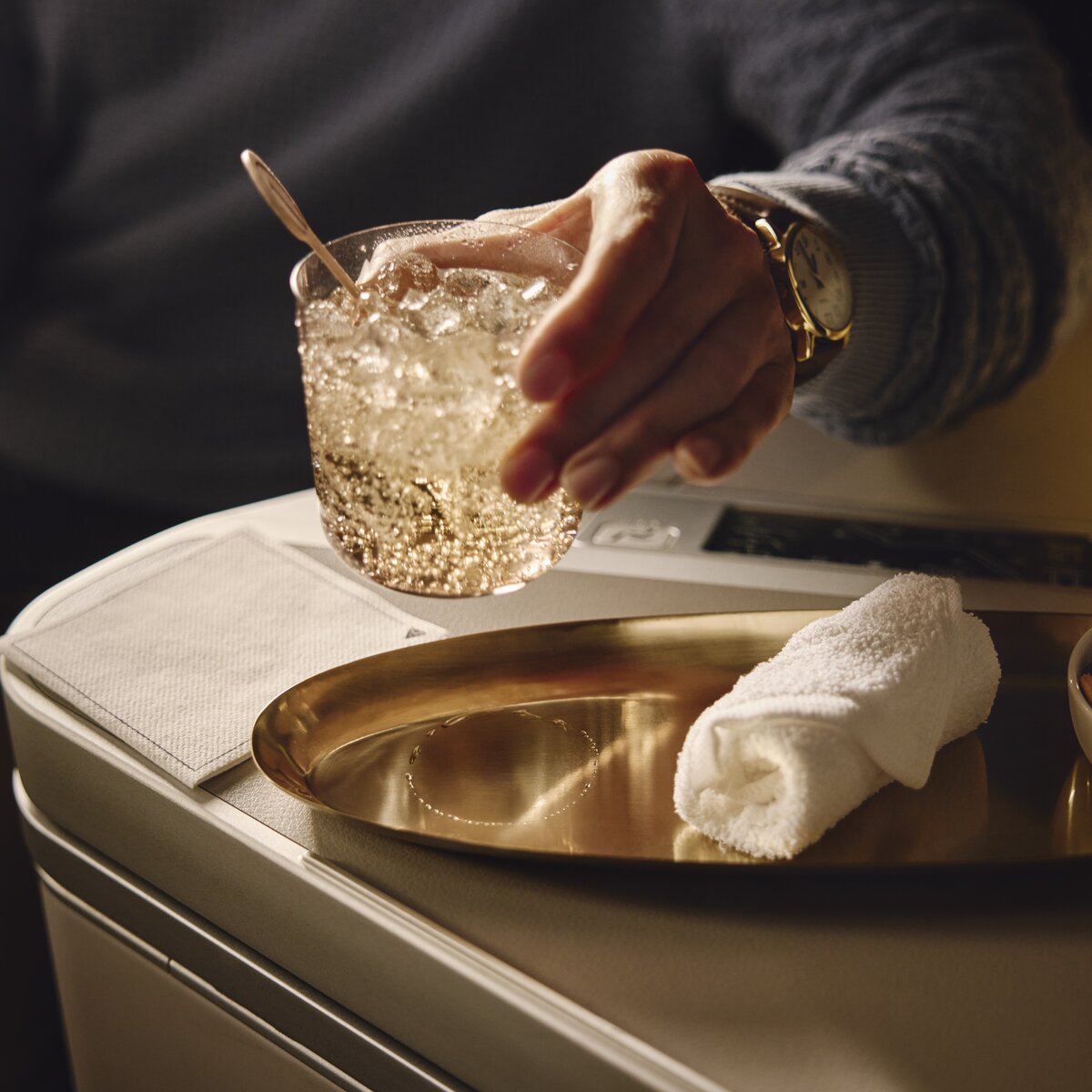 Beverage and mixed nuts served on a tray table in a Delta One suite.