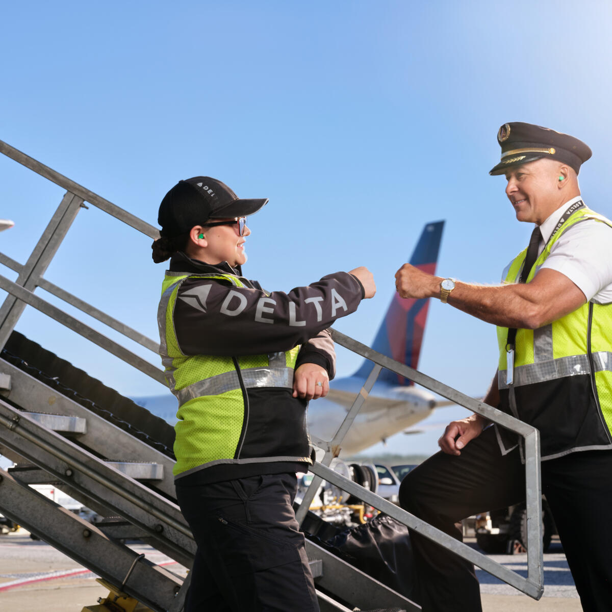 A Delta pilot and ramp employee fist-bump in this 2023 image.