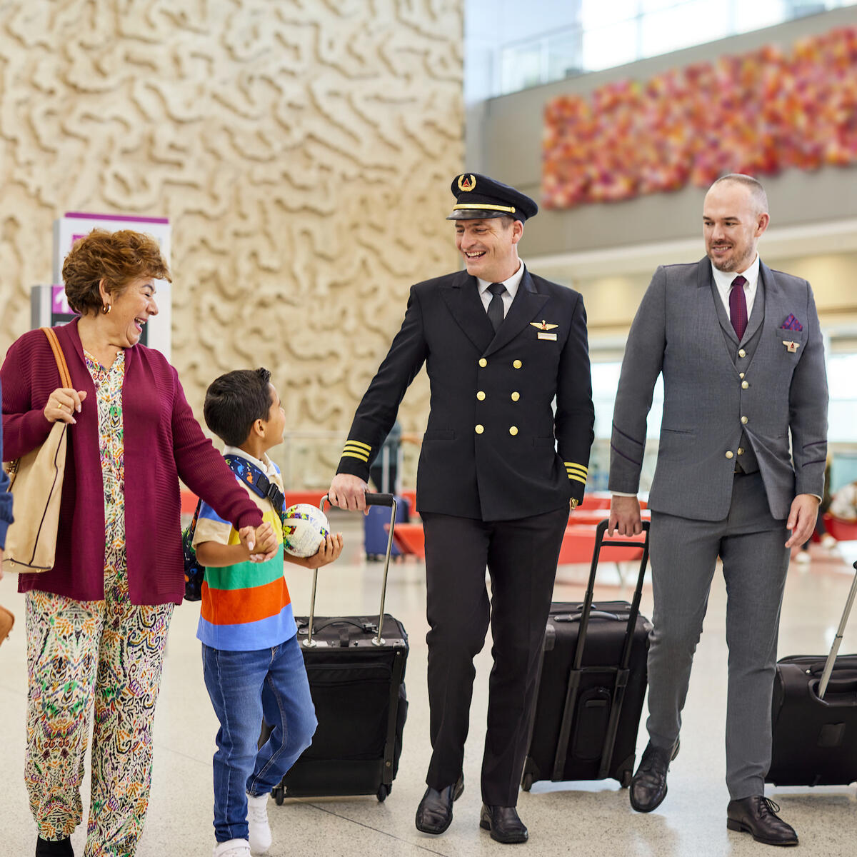 A Delta flight crew speaks with a family at an airport.