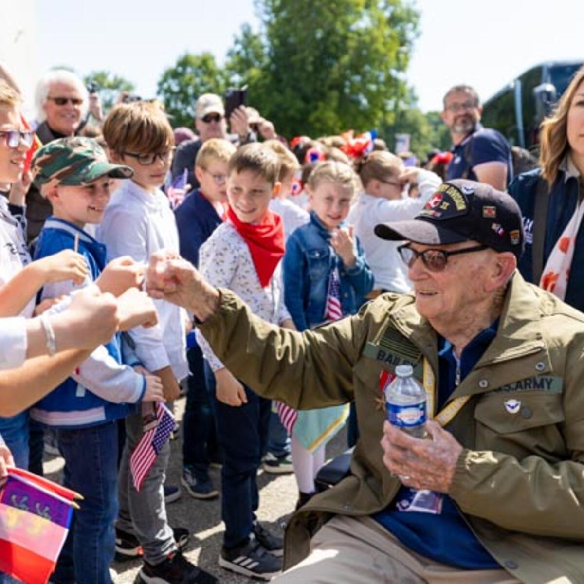 After signing countless autographs, the veterans enjoyed a ride on World War II-era vehicles to Omaha Beach, where they laid roses to remember comrades who lost their lives on those shores.