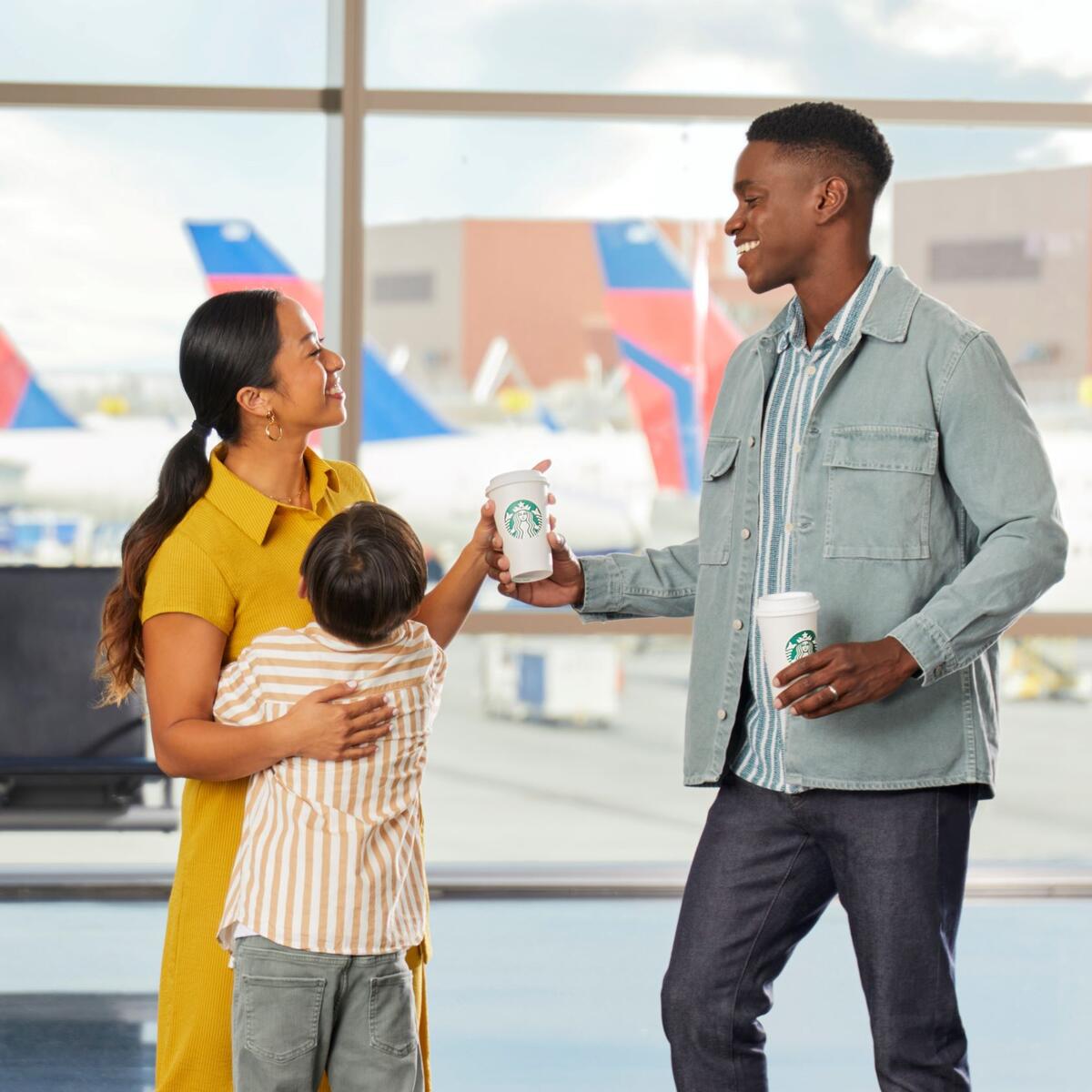 Family group of three enjoying Starbucks at airport