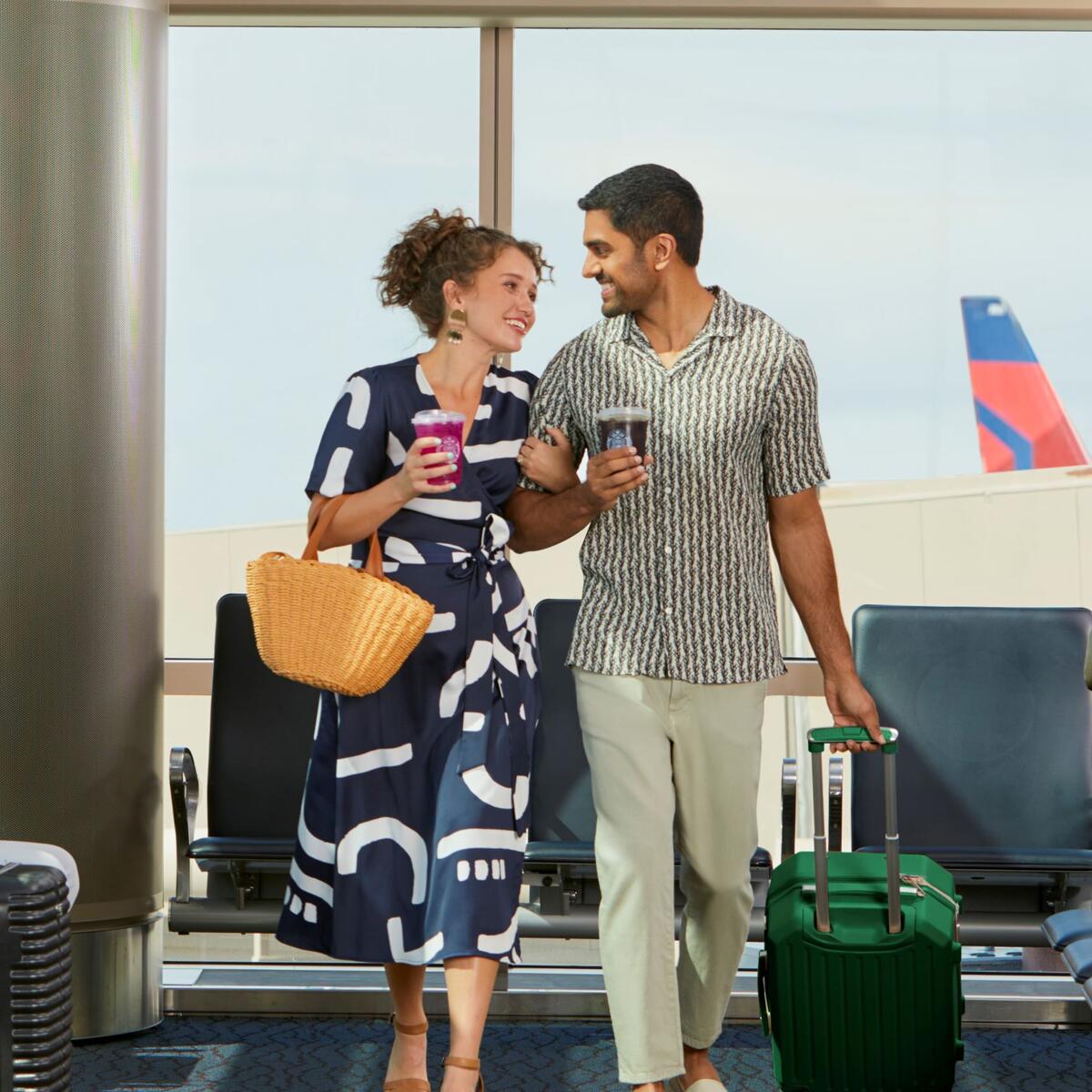 Couple in airport enjoying Starbucks beverages