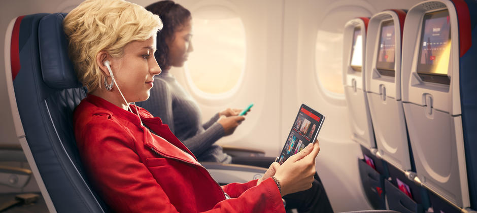 Customers use mobile devices while seated in Delta Comfort+.
