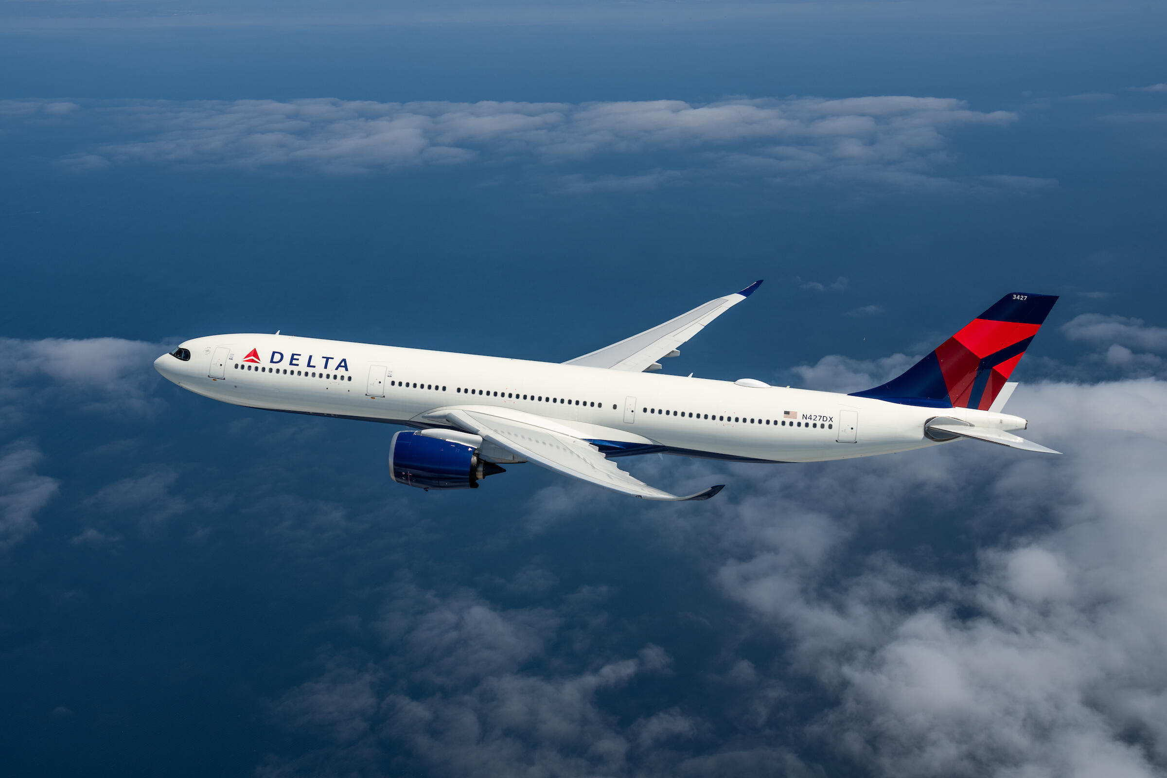 An A330-900 flying among clouds