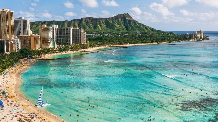 A skyline overlooking a beach and turquoise waters in Hawaii.