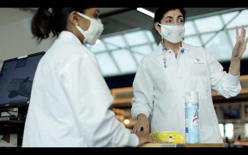 Two women in PPE using Lysol in the LaGuardia airport