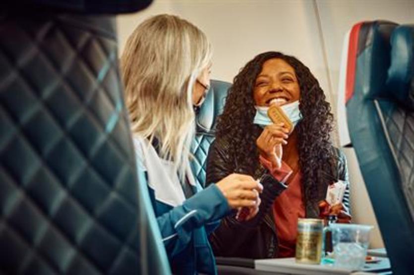 Delta customers eating snacks with masks