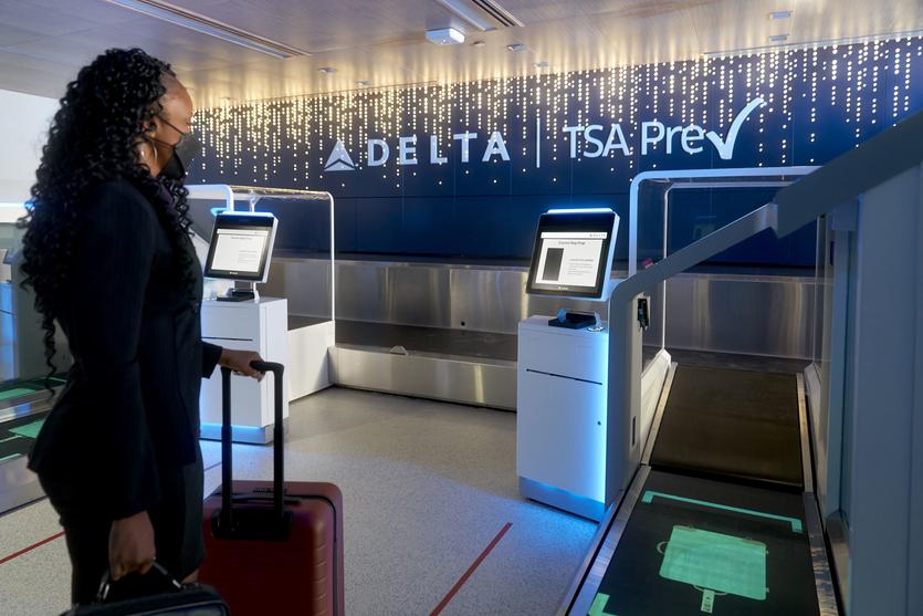 A woman uses facial recognition technology to check in.