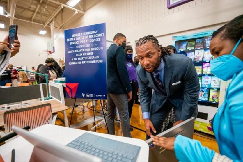 Larry Fitzgerald checks out one of the tablets presented to South Atlanta High School.