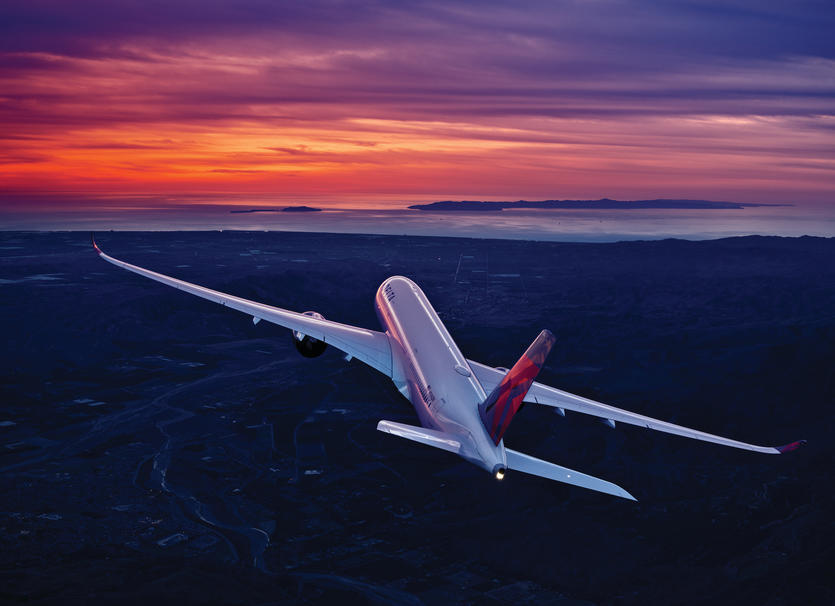 A350-900 in flight against a sunrise