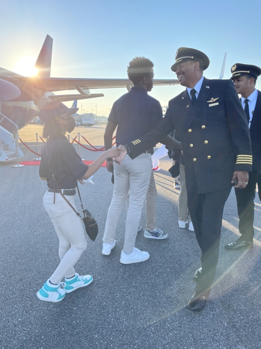 A Delta pilot greets a student participating in the 2022 Dream Flight