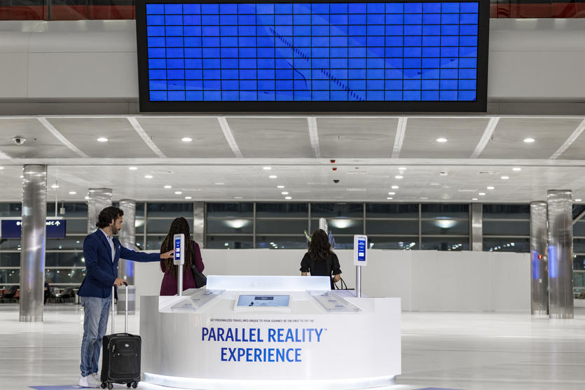 Male customer using Parallel Reality screen to check-in at a Parallel Reality Experience kiosk