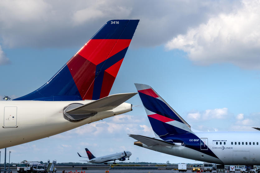 Delta and LATAM planes are shown as another plane takes off in the background in this September 2022 photo.