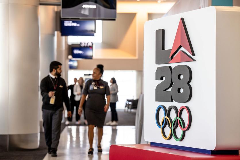 Delta employees walk through LAX near Delta's cocreated logo for LA28 on Sept. 29, 2022.
