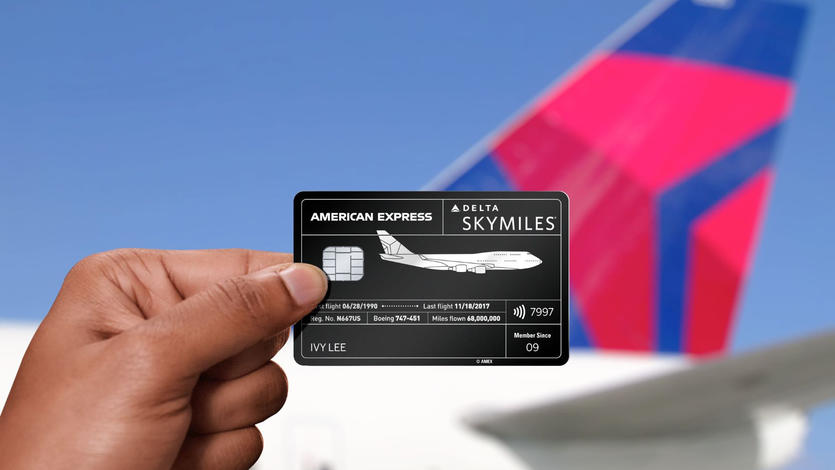 Amex card in hand with plane tail
