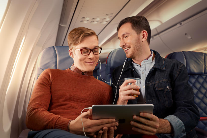 Two people use a table while seated in Delta Comfort+.