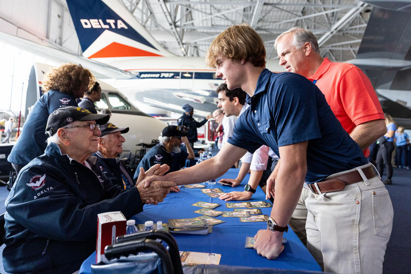 Veterans sign memorabilia and meet fans during a lunch that preceded the sendoff of more than 40 WWII veterans to Normandy, France, for the 79th annual commemoration of the 1944 D-Day invasion. 
