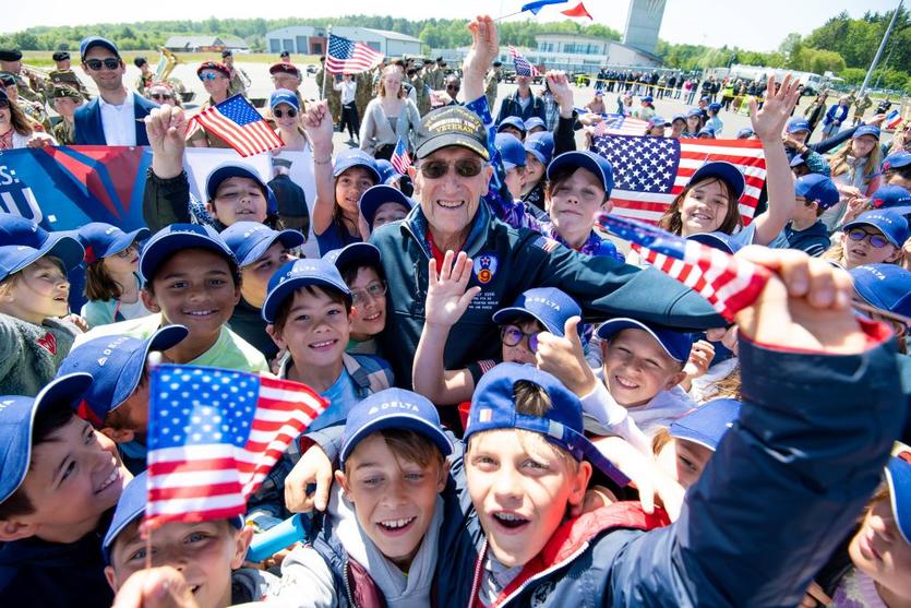 A veteran is greeted by children upon arrival in Normandy, France for the 79th annual commemoration of the 1944 D-Day invasion.