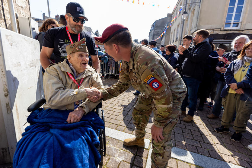 A World War II veteran is greeted by an Army Ranger in Normandy in June 2023.