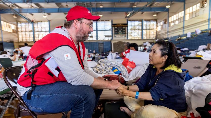 American Red Cross staffer Doyle Rader holds hands with Thao Tran