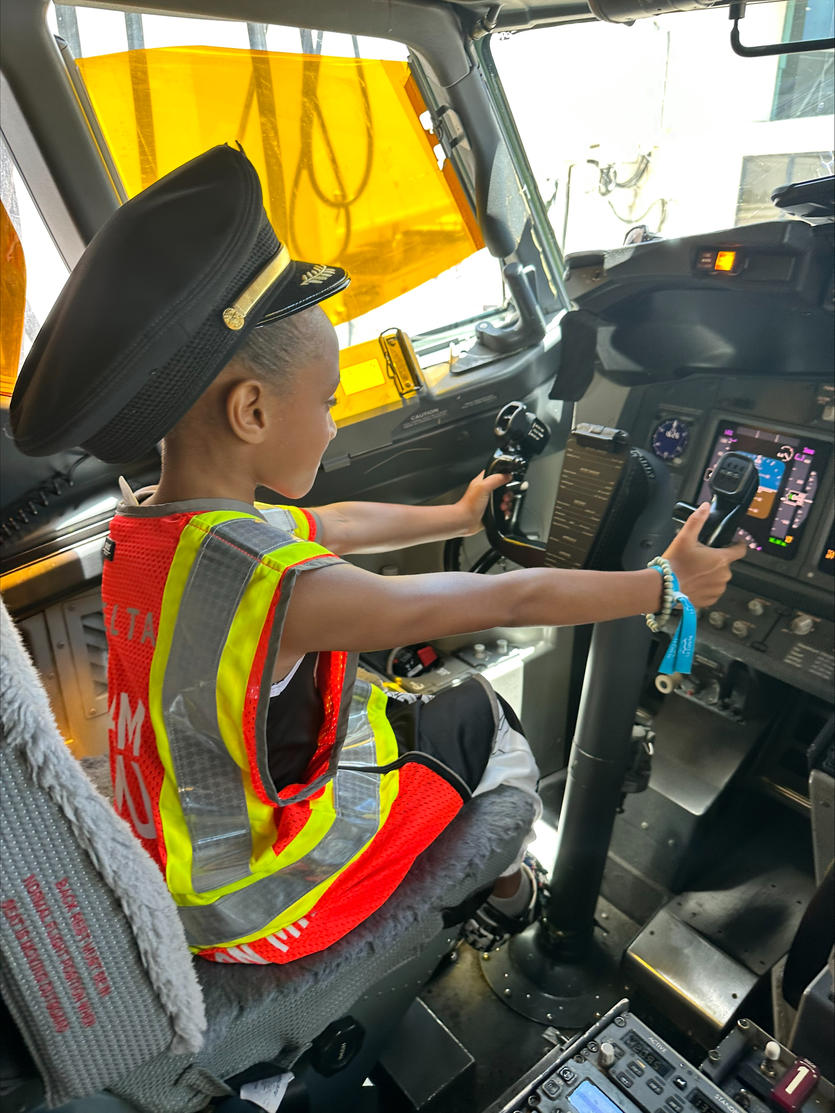 A child sits in the flight deck on an aircraft at San Juan Airport as part of a special initiative to inspire excitement about aviation.