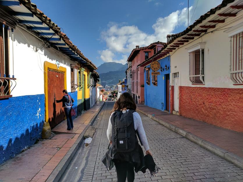 A girl wearing a backpack walks through La Candelaria, Bogota
