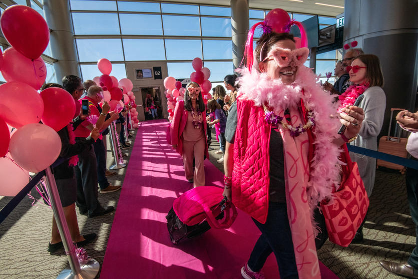 Breast cancer survivors walk a pink runway after the Delta Breast Cancer One charter flight arrived at its destination.