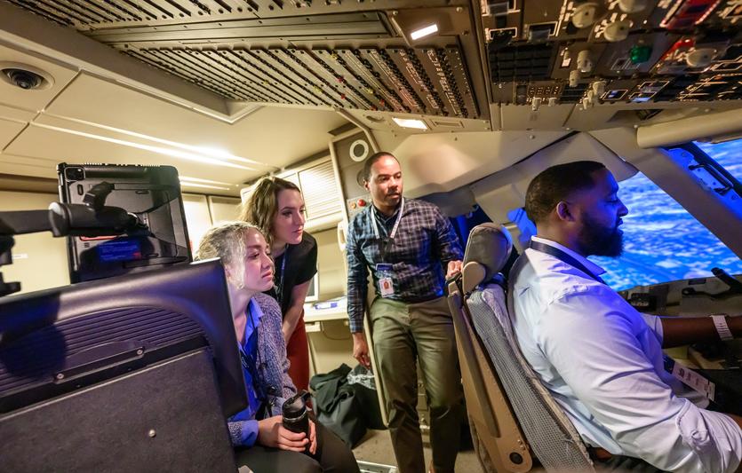 First Officer Jerome Wellons (middle) runs a flight simulator for Propel Company Path Program participants Justin Thomason, Hannah Martin and Alex Zawadzki.