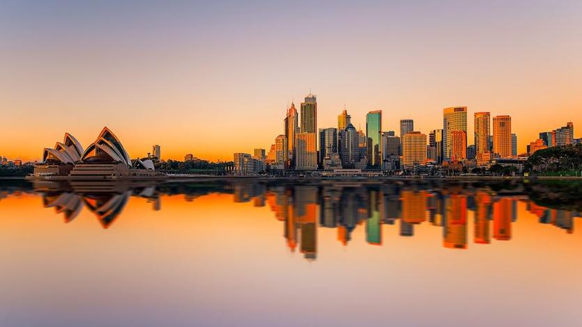 A view of downtown Sydney and the Opera House against a sunrise