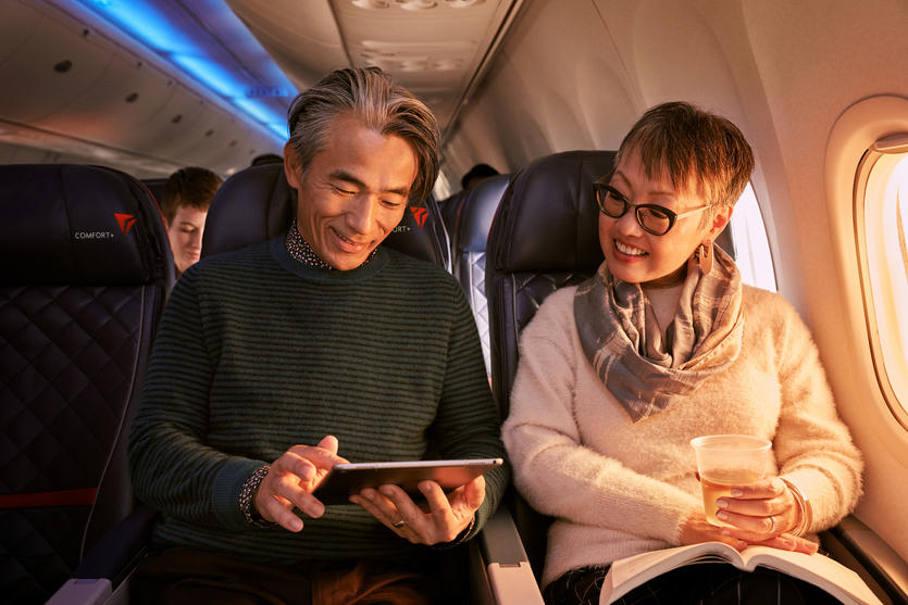 Two people use a tablet while seated in Delta Comfort+