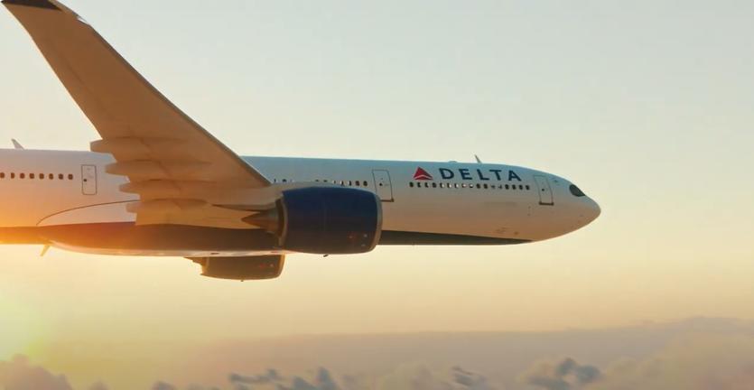 A still of a Delta plane flying against a sunset for Delta's "To See Beyond, Go Up" South America marketing campaign