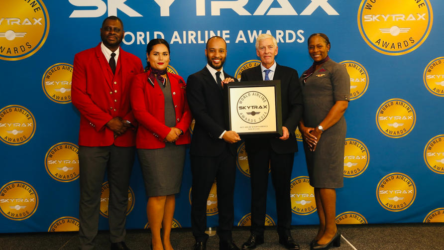 Delta employees accept a Skytrax World Airline Award from Edward Plaisted, the CEO of Skytrax.