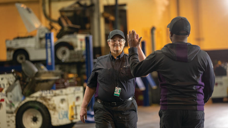 Delta employees high-five at work.