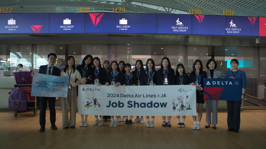 High school students pose in ICN Airport to commemorate their job shadowing experience with Delta and Junior Achievement.