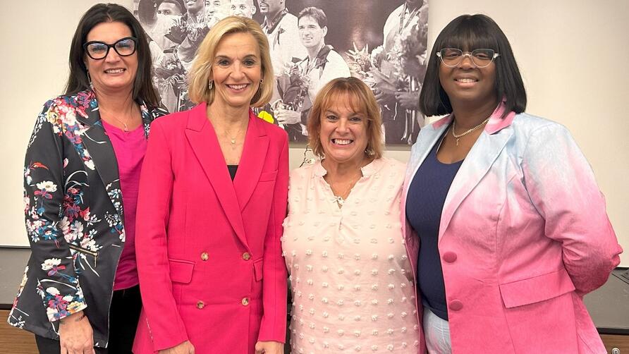 EVP and Chief People Officer Allison Ausband posing with three Delta employee breast cancer survivors.
