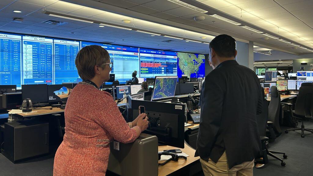 A Delta employee shows Todd O., Delta's most frequent flyer, around the OCC, the heartbeat of the operation with constant flight, emergency and weather tracking. 