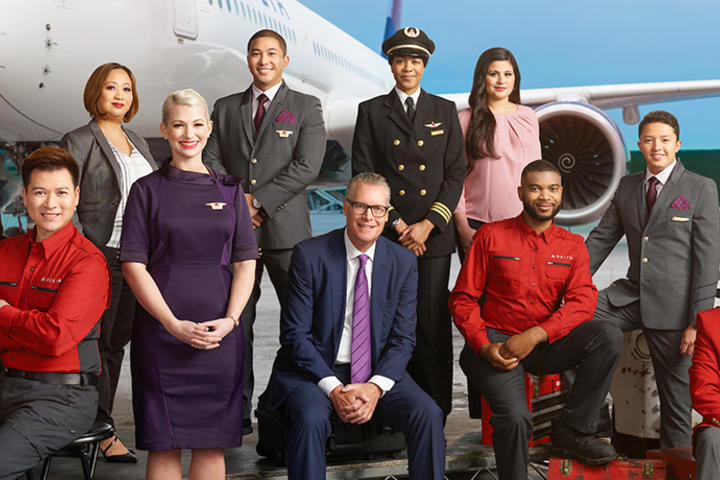 Ed, posing with Delta crew, in front of a large plane.